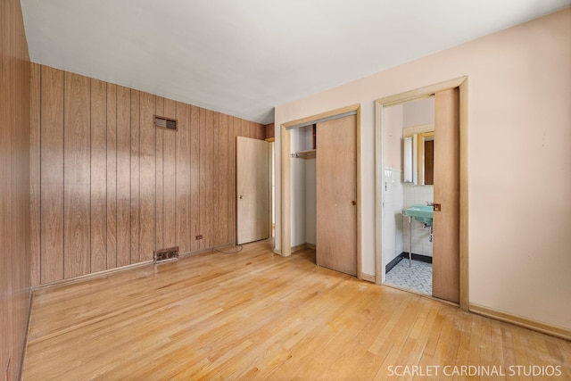 782 S Bryan St, Elmhurst, IL 60126 - unfurnished bedroom featuring light wood finished floors, wood walls, a closet, and ensuite bathroom