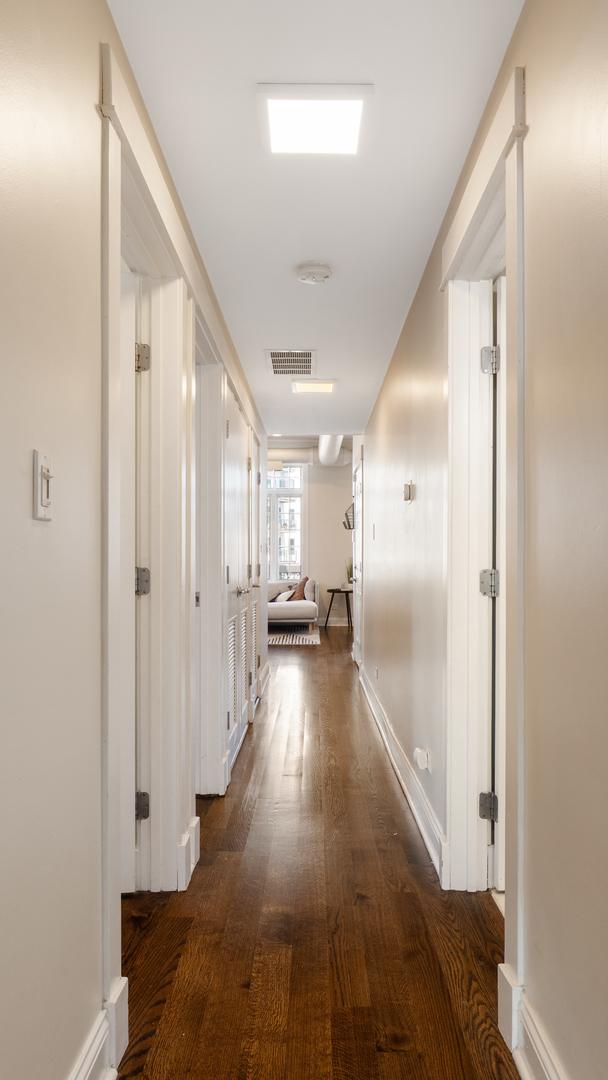 636 N Racine Ave Unit 2N, Chicago, IL 60642 - hall featuring dark wood-style flooring and baseboards