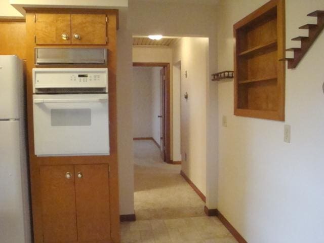 423 W Garfield Ave, Cissna Park, IL 60924 - kitchen featuring white appliances, brown cabinetry, baseboards, and open shelves