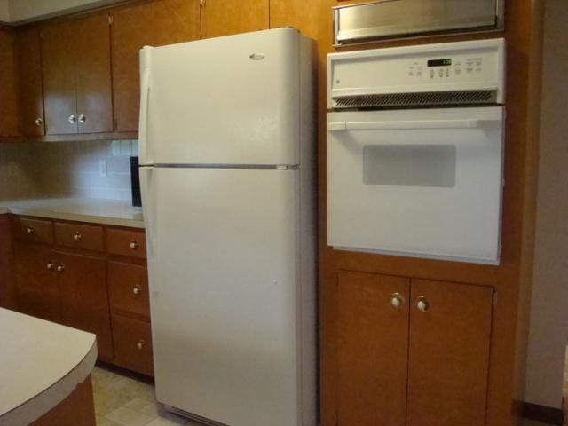 423 W Garfield Ave, Cissna Park, IL 60924 - kitchen with white appliances, brown cabinets, and light countertops