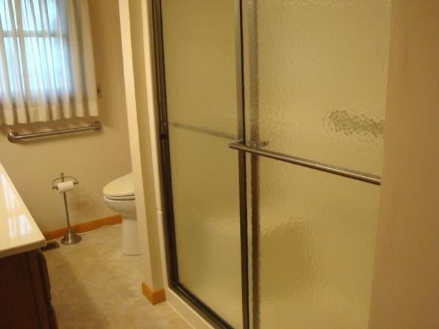 423 W Garfield Ave, Cissna Park, IL 60924 - full bath with a stall shower, vanity, toilet, and baseboards