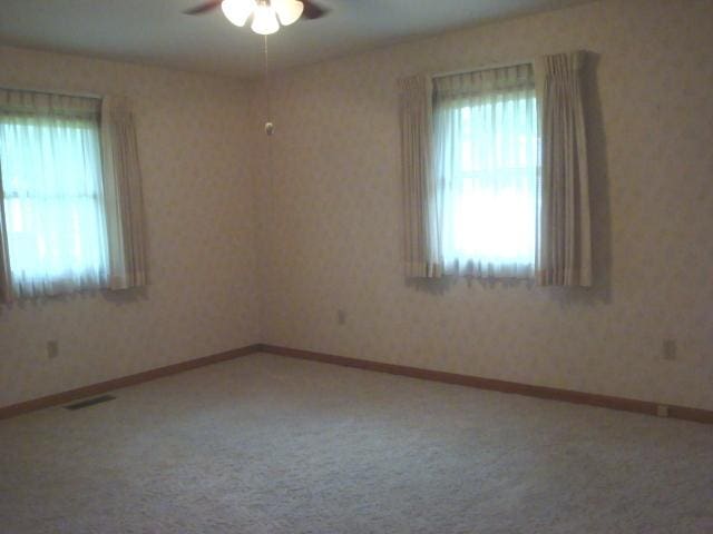423 W Garfield Ave, Cissna Park, IL 60924 - carpeted spare room featuring ceiling fan and baseboards