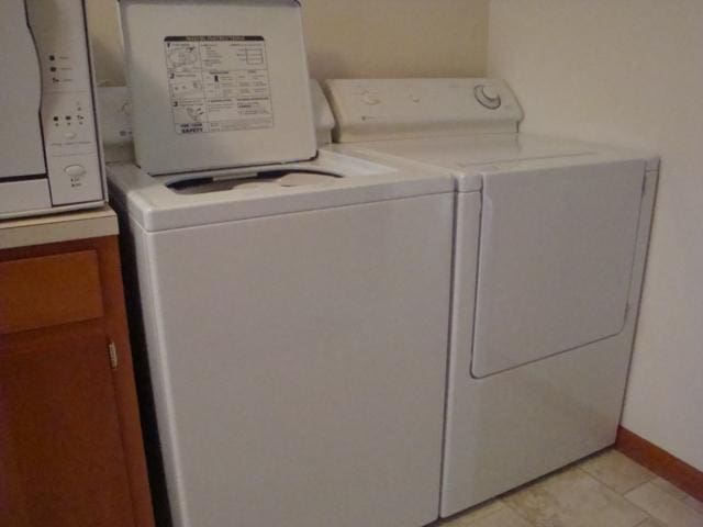 423 W Garfield Ave, Cissna Park, IL 60924 - laundry room with washing machine and dryer, cabinet space, and baseboards