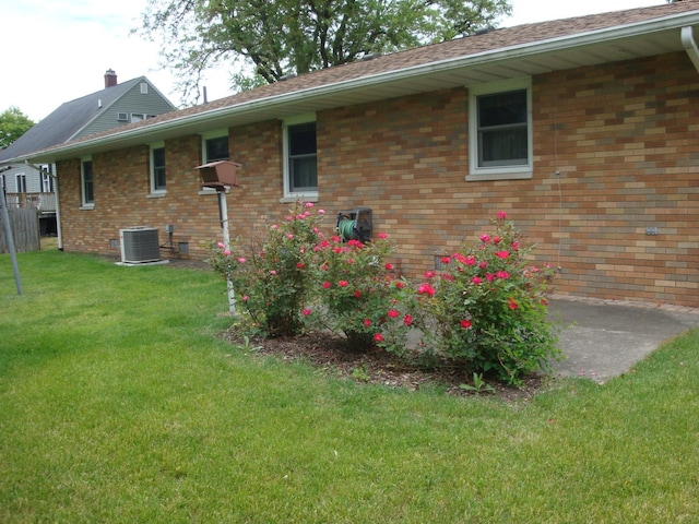 423 W Garfield Ave, Cissna Park, IL 60924 - view of side of home with central AC, a lawn, and brick siding