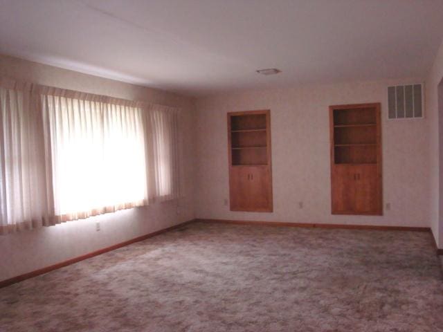 423 W Garfield Ave, Cissna Park, IL 60924 - unfurnished room with baseboards, built in features, and carpet
