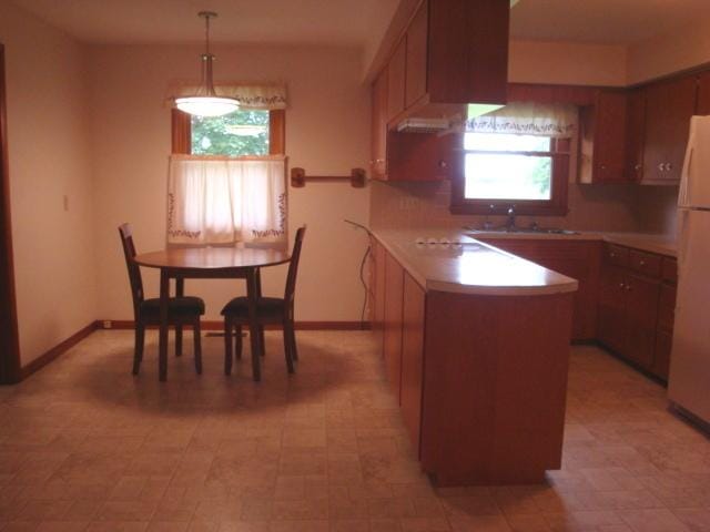 423 W Garfield Ave, Cissna Park, IL 60924 - kitchen with freestanding refrigerator, light countertops, a peninsula, a sink, and pendant lighting