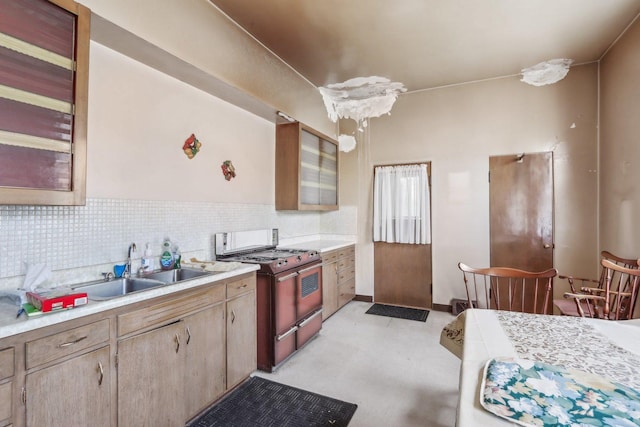 3754 W Sunnyside Ave, Chicago, IL 60625 - kitchen featuring gas stove, a sink, light countertops, and backsplash
