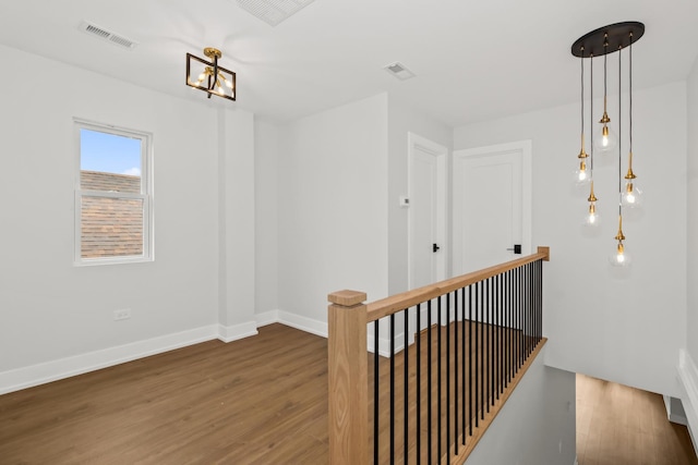 8114 S Paxton Ave, Chicago, IL 60617 - corridor featuring wood finished floors, baseboards, a chandelier, and an upstairs landing