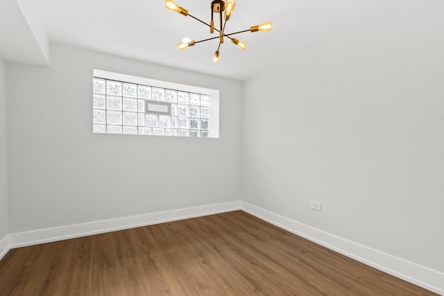 8114 S Paxton Ave, Chicago, IL 60617 - unfurnished room featuring a chandelier, baseboards, and dark wood finished floors