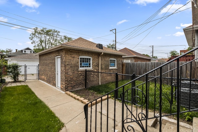 8114 S Paxton Ave, Chicago, IL 60617 - view of side of property with brick siding, roof with shingles, and a gate