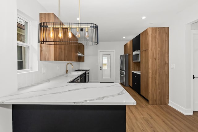 8114 S Paxton Ave, Chicago, IL 60617 - kitchen featuring modern cabinets, brown cabinets, appliances with stainless steel finishes, light wood-type flooring, and recessed lighting