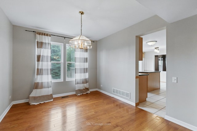 2853 Coastal Dr, Aurora, IL 60503 - empty room featuring light wood finished floors, a chandelier, and baseboards