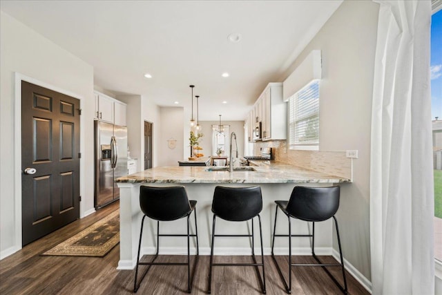 26143 S White Oak Trl, Channahon, IL 60410 - kitchen featuring stainless steel appliances, a peninsula, a sink, white cabinets, and dark wood finished floors