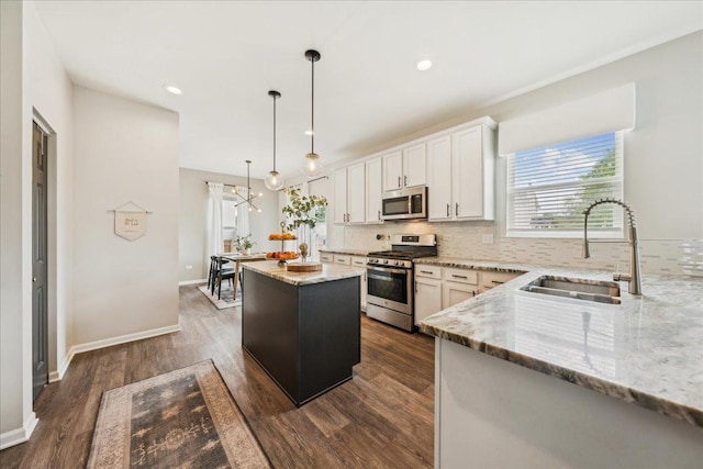 26143 S White Oak Trl, Channahon, IL 60410 - kitchen featuring appliances with stainless steel finishes, a sink, a kitchen island, decorative backsplash, and dark wood-style floors