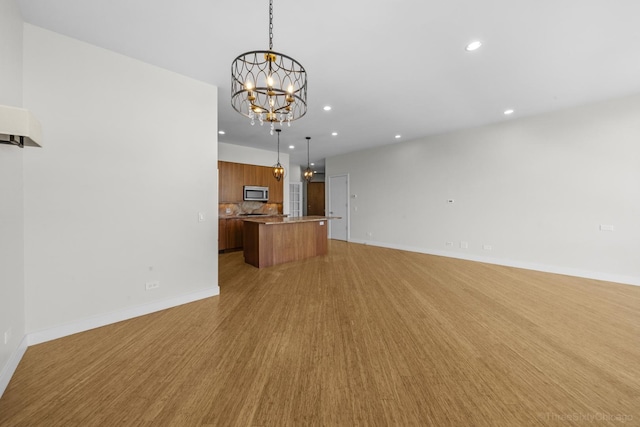 1322 N Clybourn Ave Unit 4S, Chicago, IL 60610 - unfurnished living room with a chandelier, recessed lighting, light wood-style floors, and baseboards