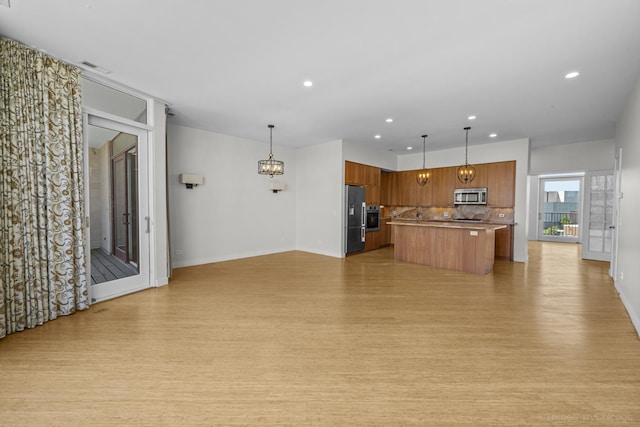 1322 N Clybourn Ave Unit 4S, Chicago, IL 60610 - kitchen featuring appliances with stainless steel finishes, open floor plan, brown cabinetry, light wood finished floors, and recessed lighting
