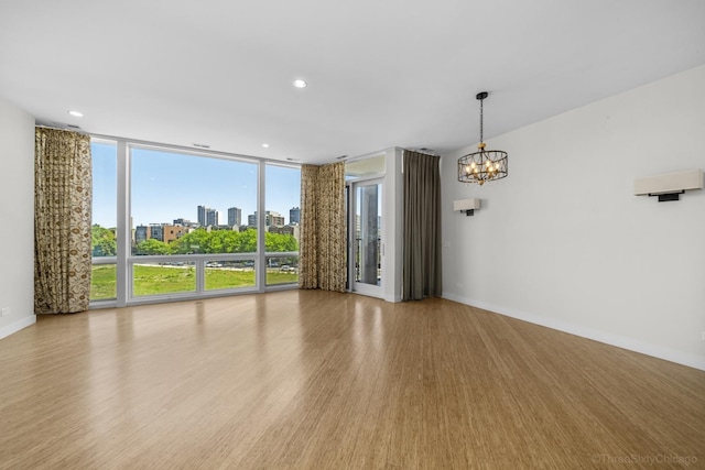1322 N Clybourn Ave Unit 4S, Chicago, IL 60610 - empty room featuring a chandelier, wood finished floors, a wall of windows, baseboards, and a city view