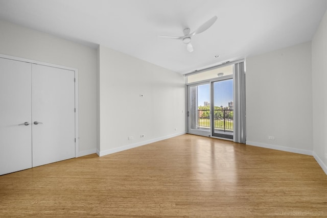 1322 N Clybourn Ave Unit 4S, Chicago, IL 60610 - unfurnished bedroom featuring access to exterior, wood finished floors, baseboards, expansive windows, and ceiling fan