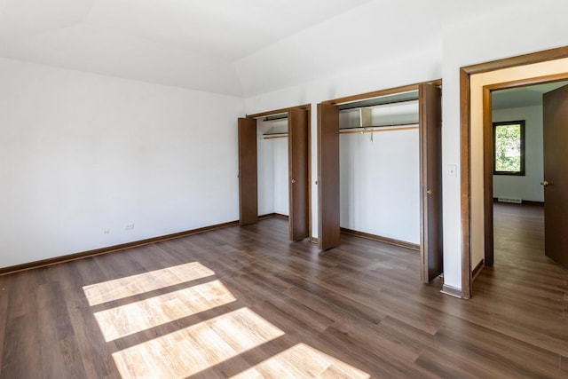 26 Marina Dr, Des Plaines, IL 60016 - unfurnished bedroom with multiple closets, dark wood-style flooring, vaulted ceiling, and baseboards