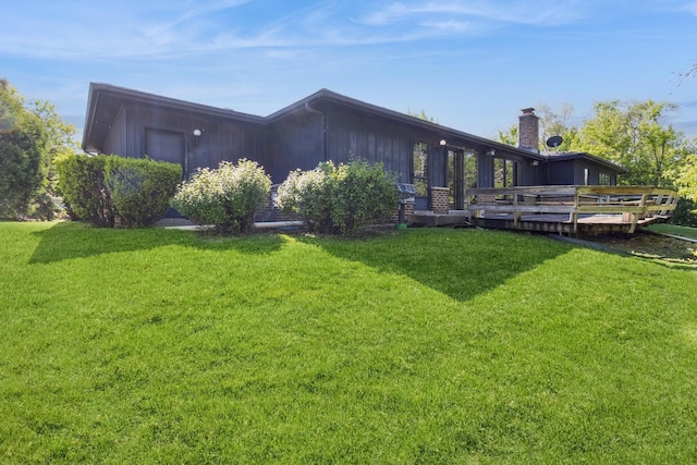 26 Marina Dr, Des Plaines, IL 60016 - rear view of house featuring a chimney, a deck, a yard, and board and batten siding