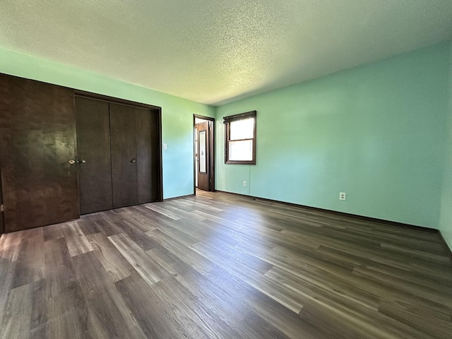 600 E 7th St, Rock Falls, IL 61071 - unfurnished bedroom featuring wood finished floors, a textured ceiling, a closet, and baseboards