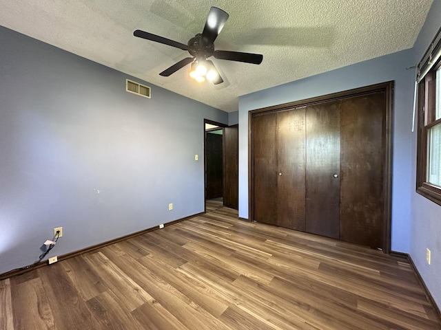 600 E 7th St, Rock Falls, IL 61071 - unfurnished bedroom with wood finished floors, a textured ceiling, a closet, baseboards, and a ceiling fan