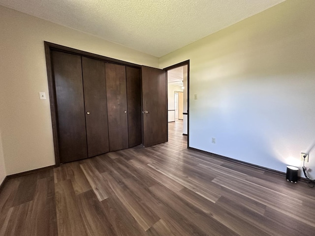 600 E 7th St, Rock Falls, IL 61071 - unfurnished bedroom featuring dark wood-style flooring, baseboards, and a textured ceiling