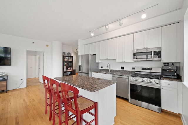 1529 S State St Unit 13G, Chicago, IL 60605 - kitchen with appliances with stainless steel finishes, a sink, light wood-style flooring, a kitchen breakfast bar, and a center island