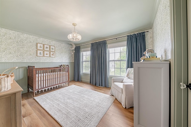 15905 Rolland Dr, Manhattan, IL 60442 - bedroom with wallpapered walls, crown molding, a wainscoted wall, a chandelier, and light wood-style floors