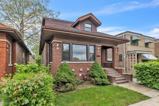 8127 S Jeffery Blvd, Chicago, IL 60617 - bungalow featuring brick siding and a front yard