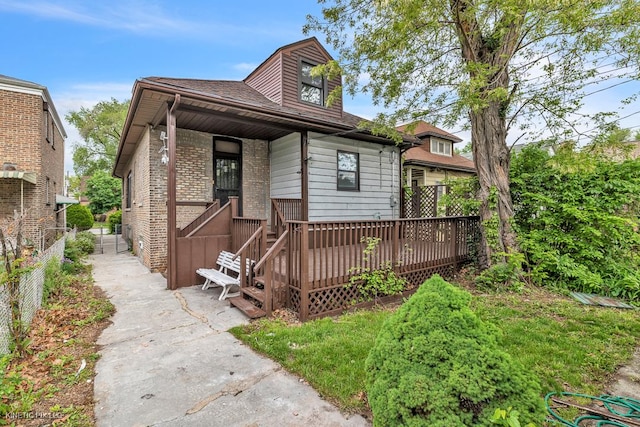 8127 S Jeffery Blvd, Chicago, IL 60617 - view of front facade featuring brick siding, roof with shingles, and a wooden deck