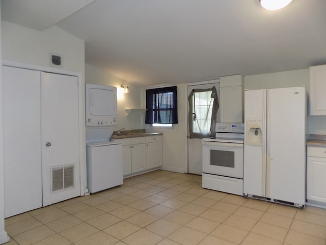 7818 Mildred Rd, Machesney Park, IL 61115 - kitchen with white appliances, estacked washer and dryer, vaulted ceiling, white cabinetry, and light countertops