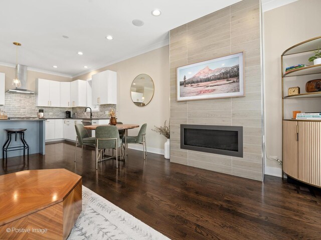 3037 W Belmont Ave Unit 2W, Chicago, IL 60618 - living room featuring ornamental molding, dark wood-type flooring, recessed lighting, a tile fireplace, and baseboards