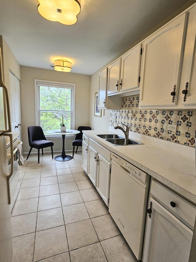 1730 Hinman Ave Unit 4F, Evanston, IL 60201 - kitchen with white dishwasher, a sink, light tile patterned floors, light countertops, and decorative backsplash