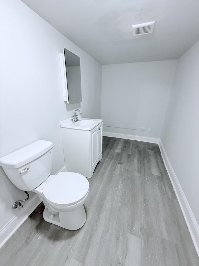 1435 S 57th Ave, Cicero, IL 60804 - bathroom with toilet, wood finished floors, vanity, and baseboards