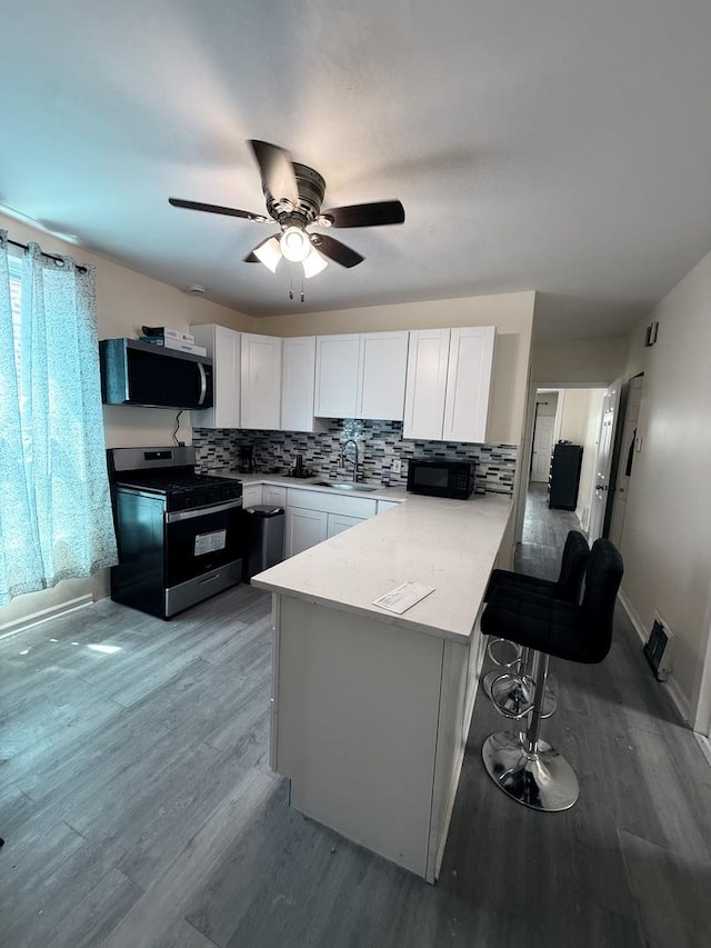 1435 S 57th Ave, Cicero, IL 60804 - kitchen featuring appliances with stainless steel finishes, a peninsula, a sink, and backsplash