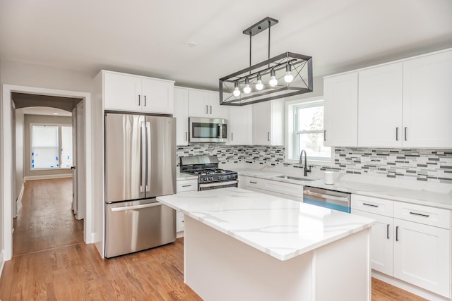 2101 W 82nd Pl, Chicago, IL 60620 - kitchen with appliances with stainless steel finishes, a sink, a center island, decorative backsplash, and white cabinets