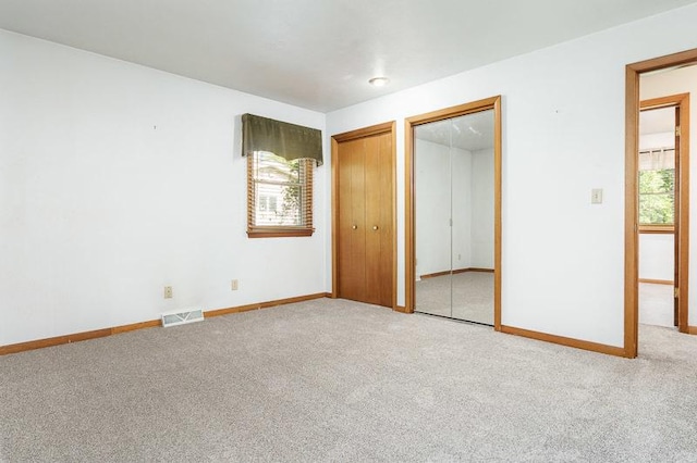 1322 Empire Ct, Freeport, IL 61032 - unfurnished bedroom featuring two closets, carpet flooring, and baseboards