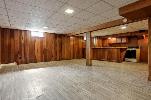 1322 Empire Ct, Freeport, IL 61032 - below grade area featuring wooden walls, light wood-style flooring, and a drop ceiling