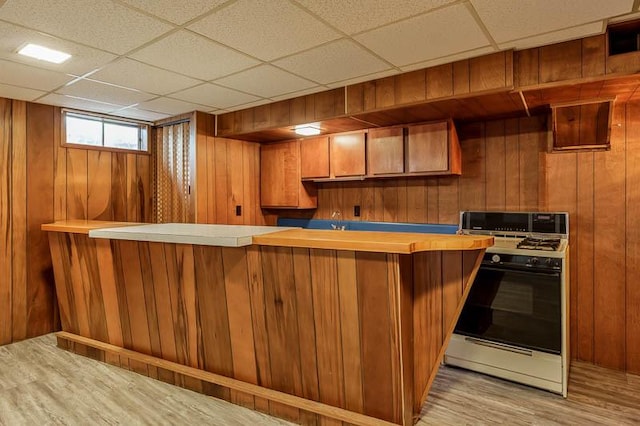 1322 Empire Ct, Freeport, IL 61032 - kitchen with range with gas cooktop, light wood-type flooring, wooden walls, a paneled ceiling, and brown cabinetry