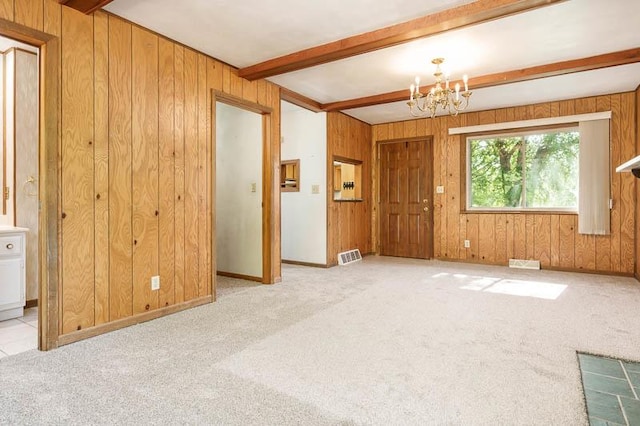 1322 Empire Ct, Freeport, IL 61032 - unfurnished living room with wooden walls, a chandelier, beam ceiling, and carpet floors