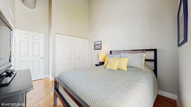2025 S Indiana Ave Unit 503, Chicago, IL 60616 - bedroom featuring a closet, light wood-type flooring, baseboards, and a high ceiling