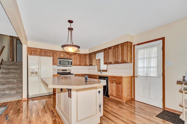 16560 Currant Ave, Tinley Park, IL 60487 - kitchen with stainless steel appliances, light countertops, light wood-style floors, brown cabinetry, and a kitchen island