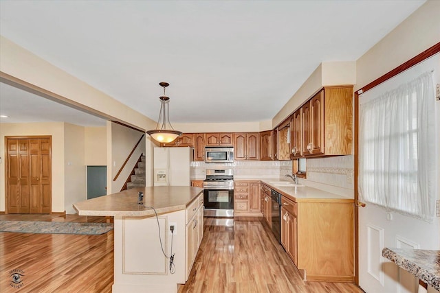 16560 Currant Ave, Tinley Park, IL 60487 - kitchen featuring appliances with stainless steel finishes, a sink, light wood-type flooring, a center island, and hanging light fixtures
