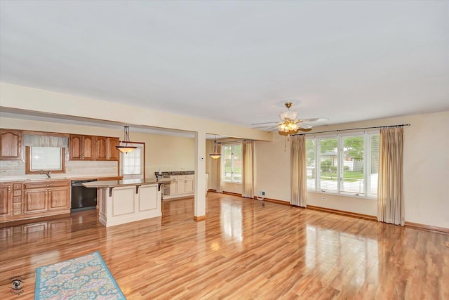 16560 Currant Ave, Tinley Park, IL 60487 - unfurnished living room featuring light wood-style floors, a ceiling fan, a sink, and baseboards