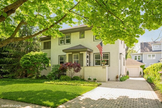 310 Fairview Ave, Winnetka, IL 60093 - view of front of home with stucco siding, a front lawn, decorative driveway, and a detached garage