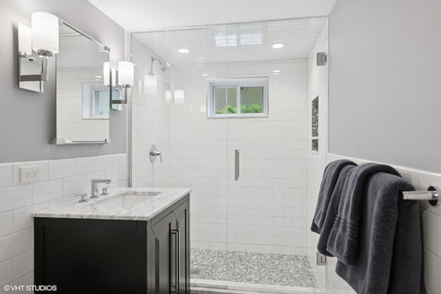 310 Fairview Ave, Winnetka, IL 60093 - bathroom with tile walls, a shower stall, vanity, wainscoting, and recessed lighting