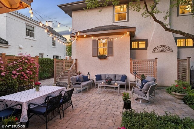 310 Fairview Ave, Winnetka, IL 60093 - patio terrace at dusk with outdoor lounge area, a patio area, stairway, and outdoor dining area