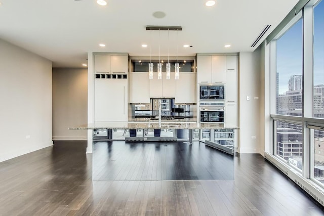 110 W Superior St Unit 1703, Chicago, IL 60654 - kitchen featuring oven, built in microwave, modern cabinets, a breakfast bar, and light stone counters
