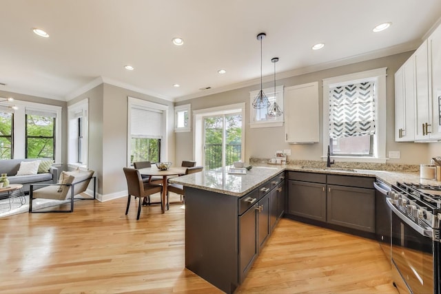 3706 W Wrightwood Ave Unit 3A, Chicago, IL 60647 - kitchen featuring a sink, a peninsula, stainless steel gas range, white cabinets, and crown molding
